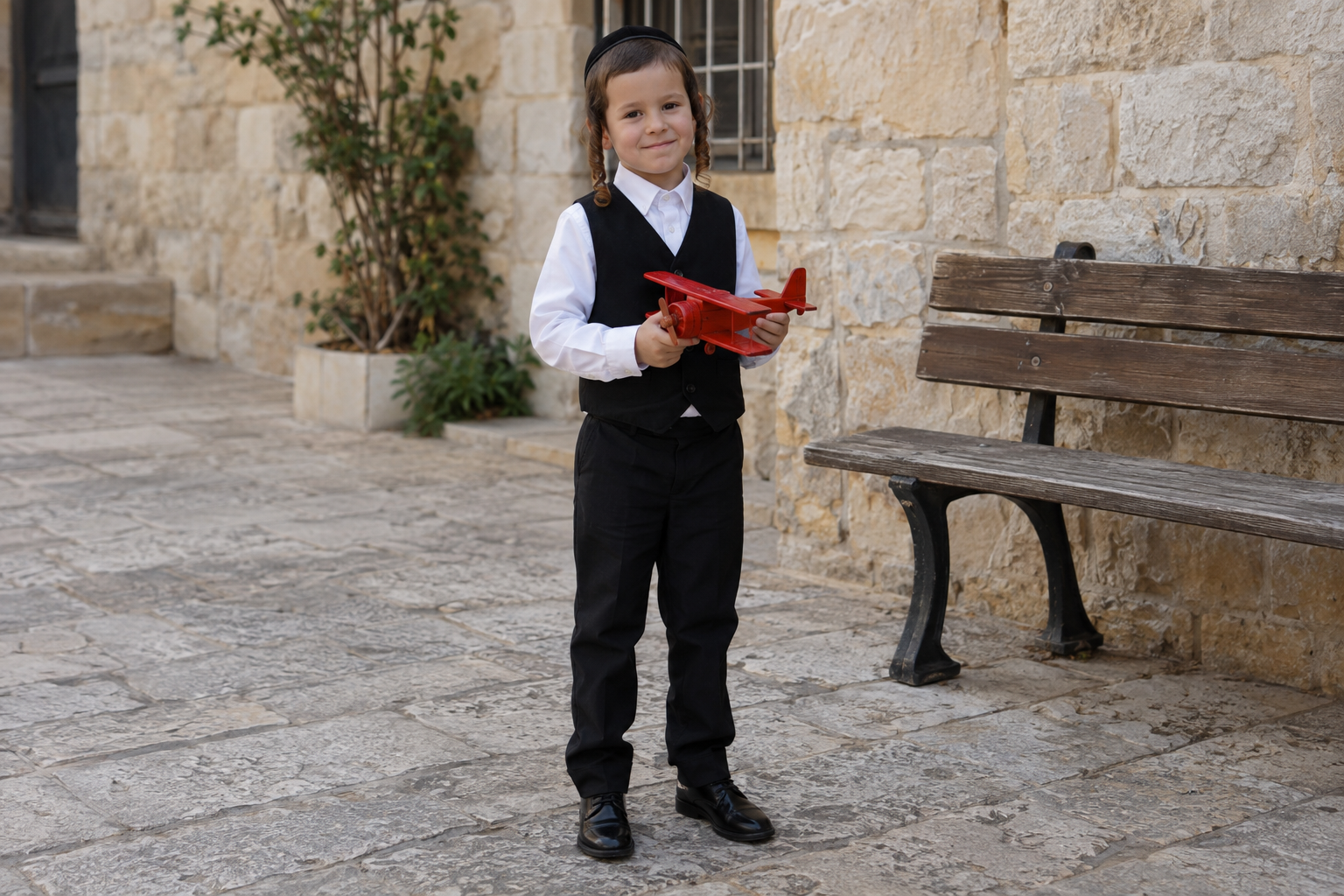 התמונה השנייה מגדירה את הדמות: ילד חסידי שמחזיק מטוס אדום.